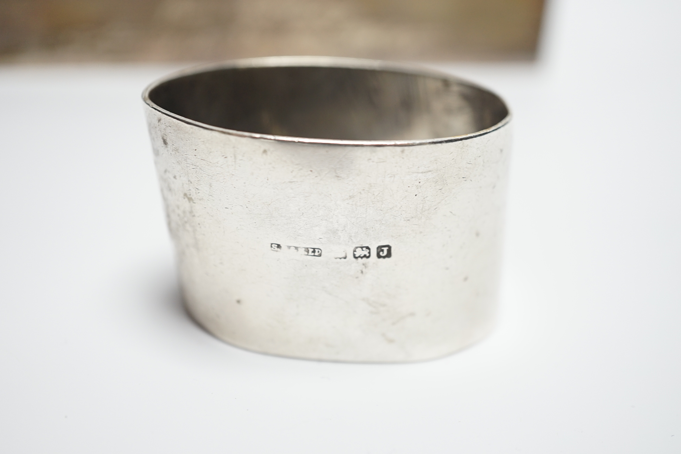A modern part engine turned silver cigarette box, with engraved inscription, 16cm and a silver serviette ring.